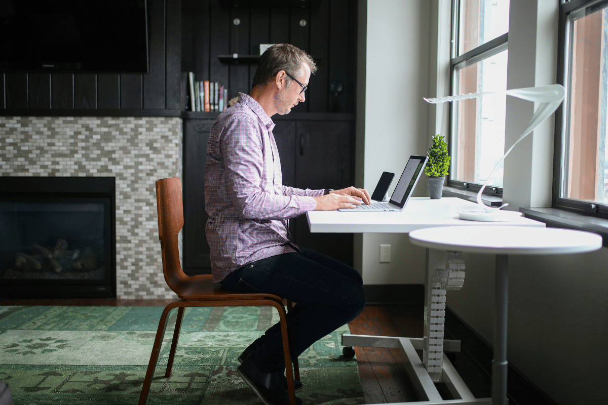 Man sitting outdoors on a bench holding his knee with both hands, illustrating everyday knee discomfort and leg stiffness associated with anterior thigh tightness.