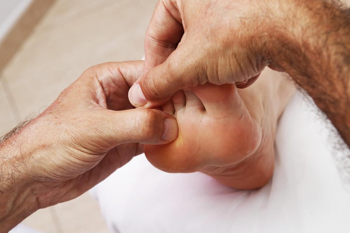 Close-up of a therapist massaging the sole of a foot to relieve heel pain and support plantar fasciitis recovery,  promoting improved circulation, arch support, and daily foot comfort.