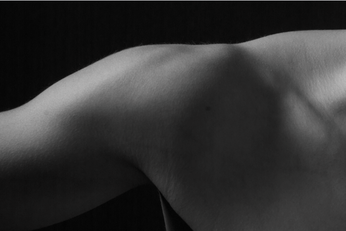 Close-up of upper back and shoulder blade muscles highlighting soft tissue tension and trapezius anatomy relevant to chest and thoracic mobility restriction