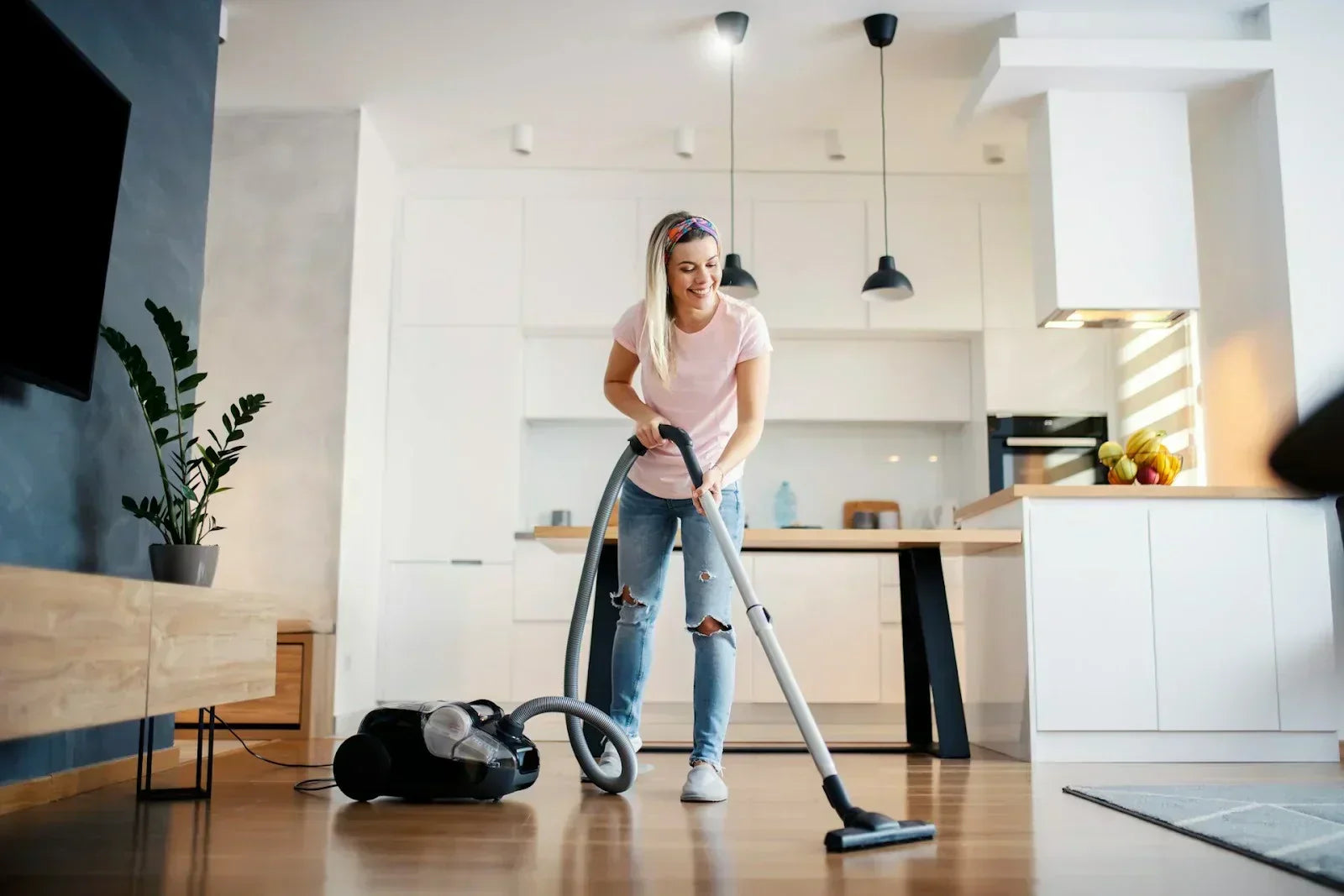 Woman vacuuming in her home, demonstrating everyday standing and walking activities that can aggravate or be improved by simple Tarsal Tunnel Syndrome relief strategies.