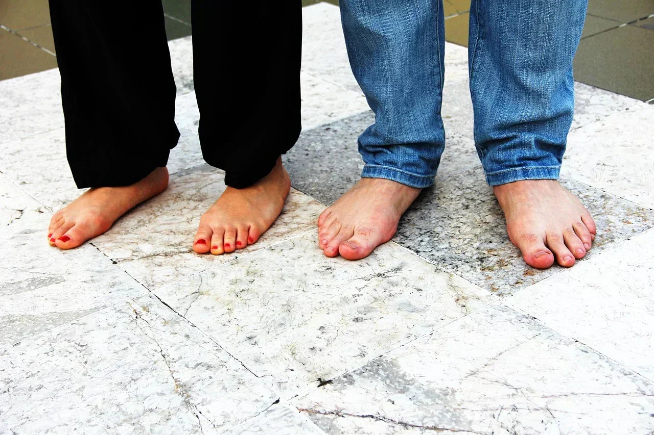 Close-up view of a human foot with a low arch, illustrating flat feet or fallen arches and their effect on foot alignment, balance, and weight distribution during standing and walking.