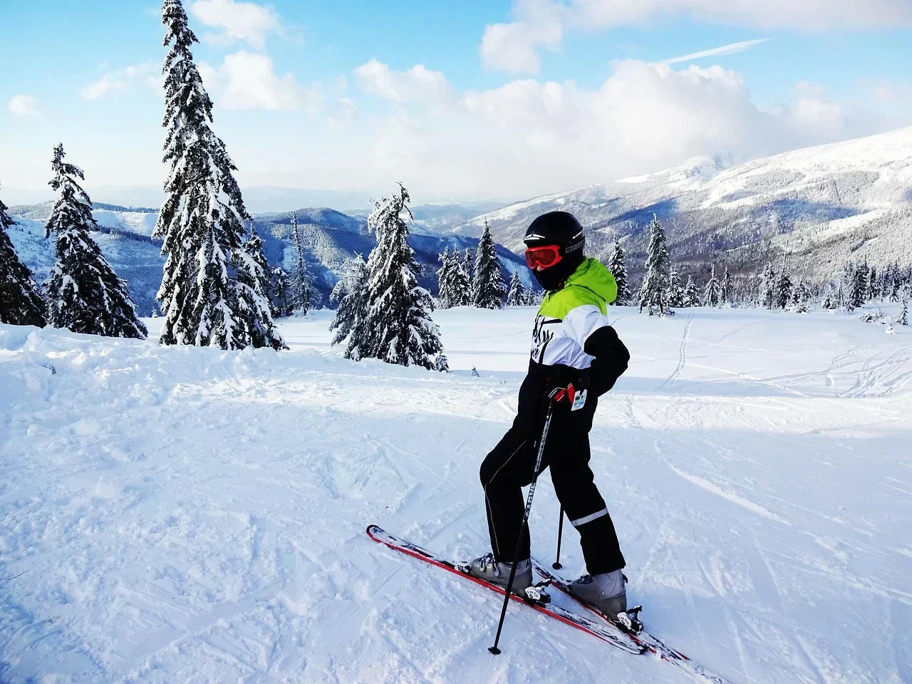 Skier standing on a snowy mountain slope in full gear, emphasizing foot alignment, forefoot loading, and toe mechanics relevant to hammertoe recovery and athletic performance.