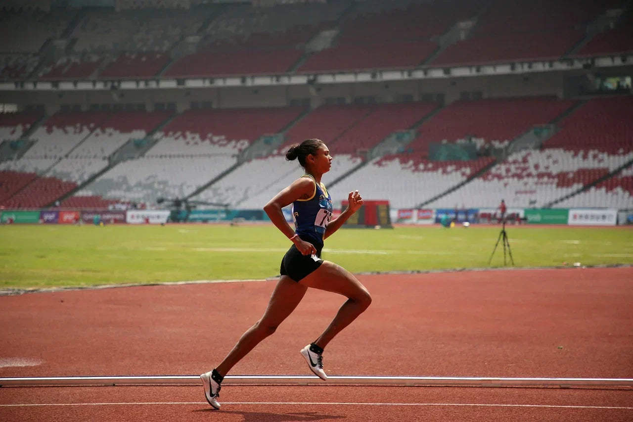 Athlete running on a track, representing foot performance and Morton’s Neuroma recovery through R3 LOAD Method™ strategies focused on mobility, balance, and circulation.