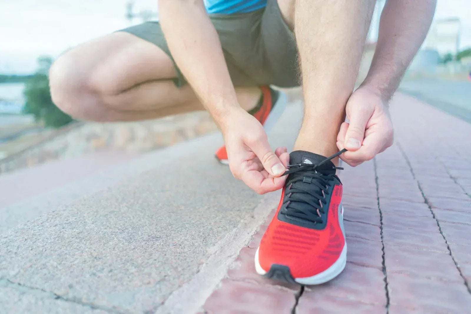 Person tying running shoes, symbolizing foot care and proper footwear choices.