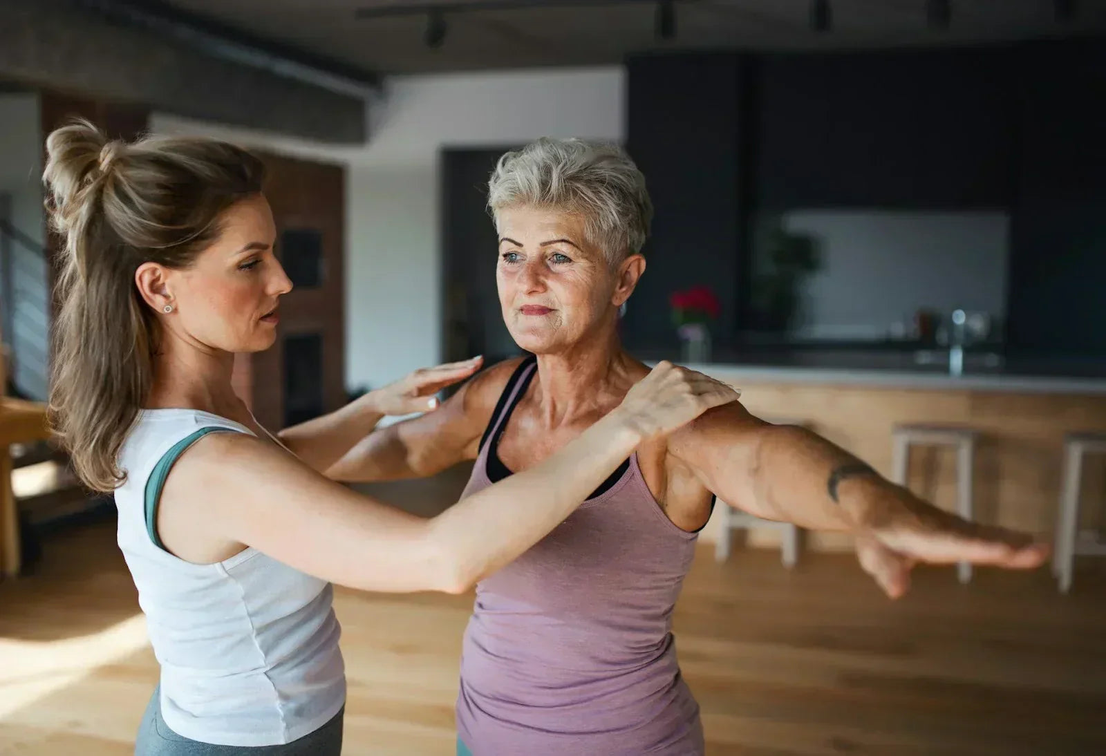 Clinician assisting an older adult with guided mobility exercises indoors, representing recovery strategies and professional support for peripheral neuropathy management.
