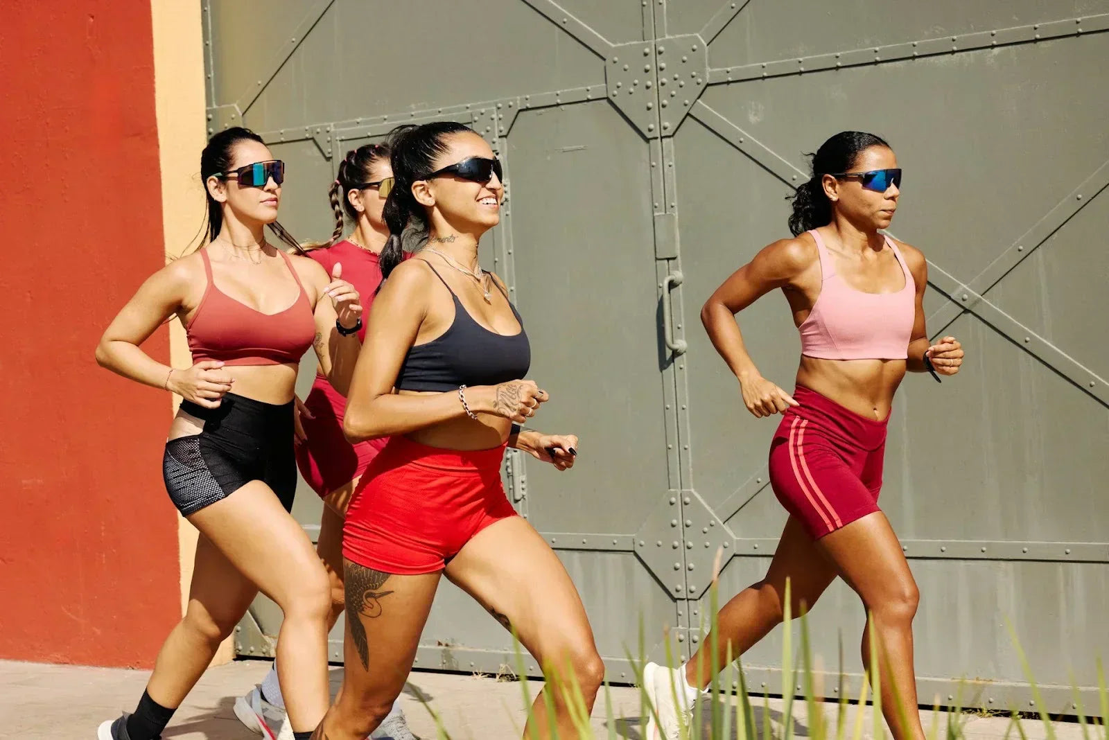 Group of women running outdoors in athletic wear, representing endurance training, movement, and post-run recovery awareness for athletes.