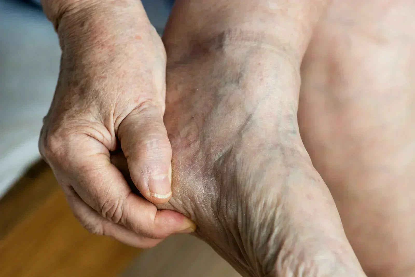 Close-up of an older adult holding their heel and arch to explore an area of tension in the foot.