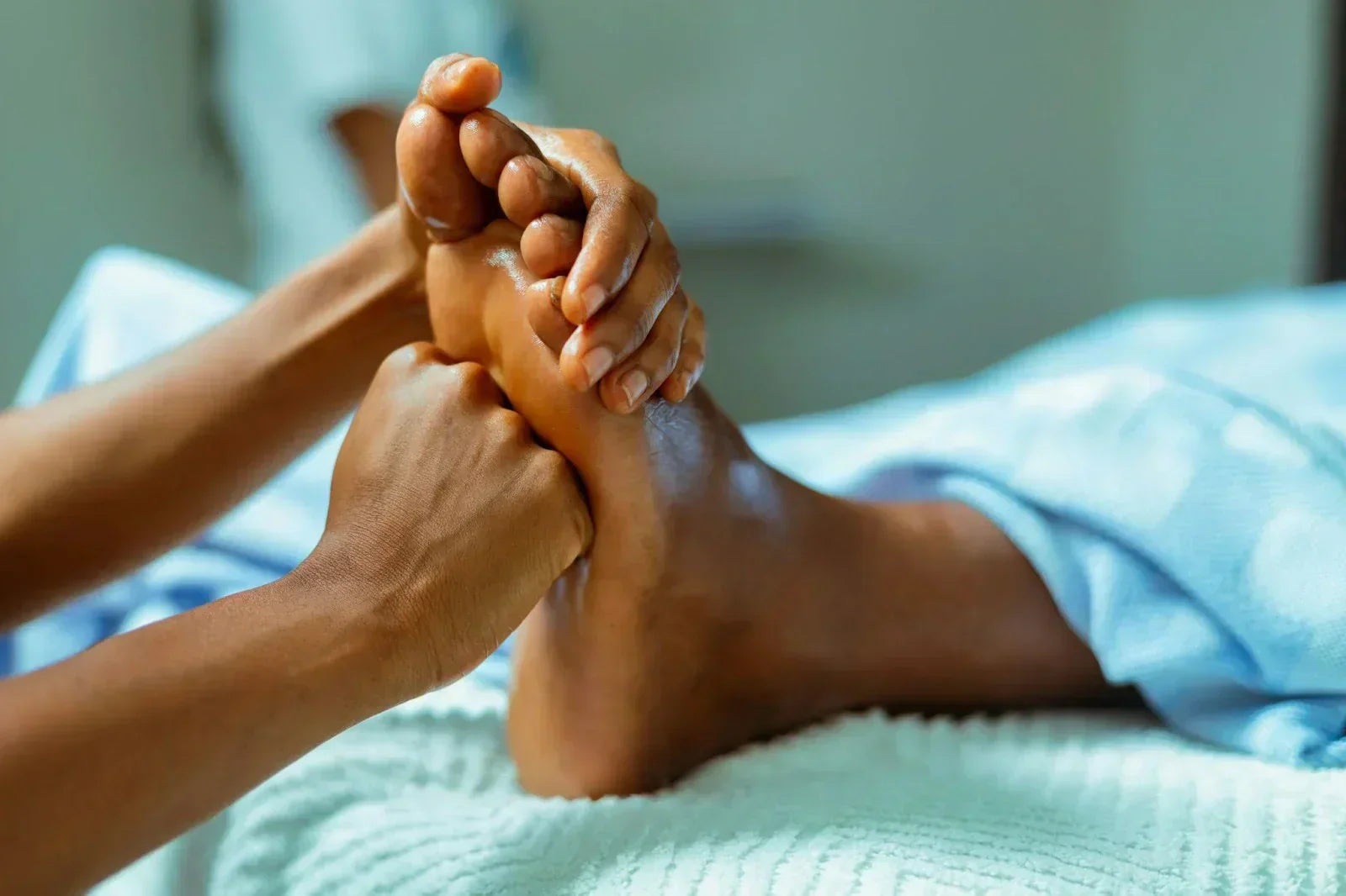 Close-up of a clinician performing manual foot therapy, applying targeted pressure to the arch and toes to address stiffness, tension, and high-arch mobility limitations.