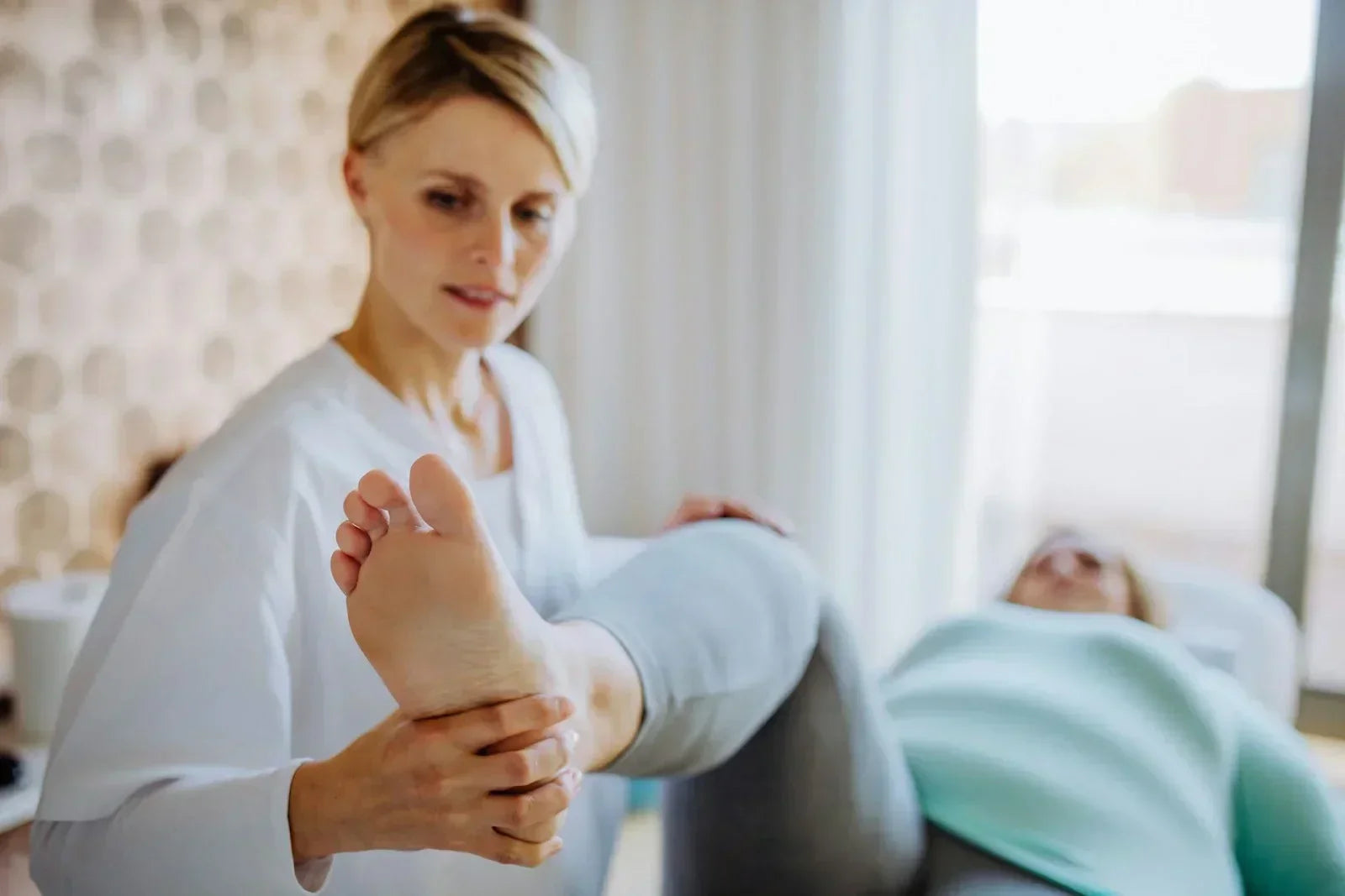 Clinician performing a general foot and ankle mobility assessment, observing movement patterns and medial ankle structures.